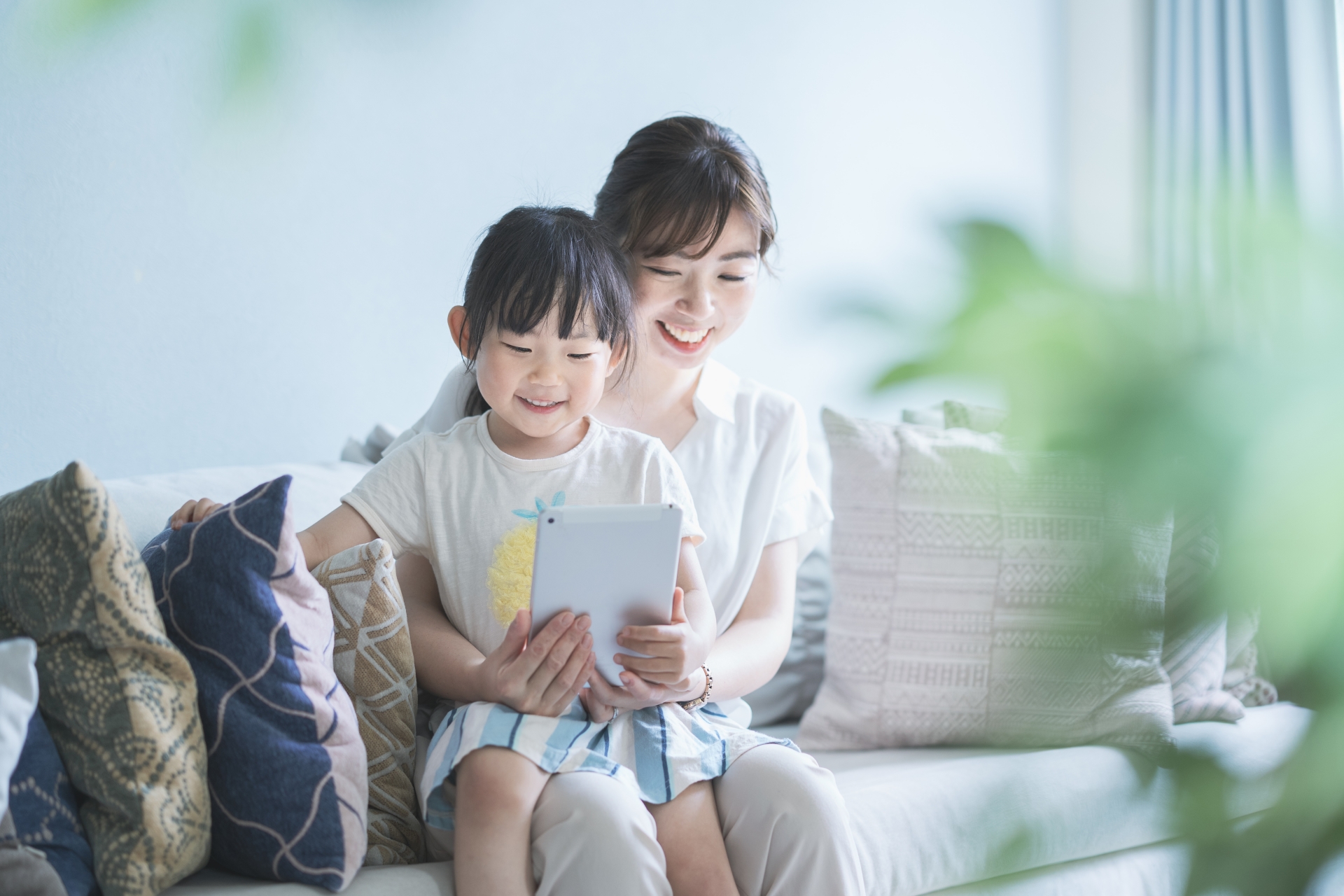 自宅でタブレットを一緒に見る親子のイメージ